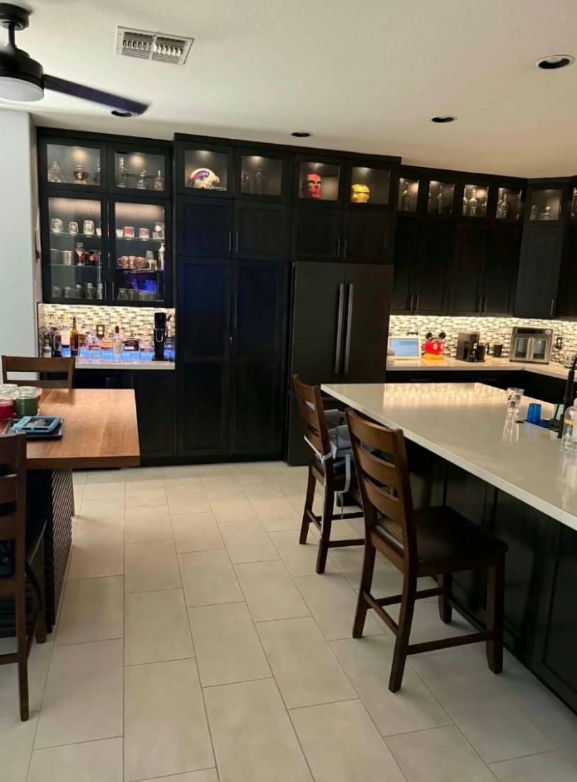 Espresso kitchen cabinets with lit glass-front uppers