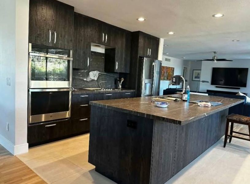 Dark woodgrain kitchen with double wall ovens and a large island